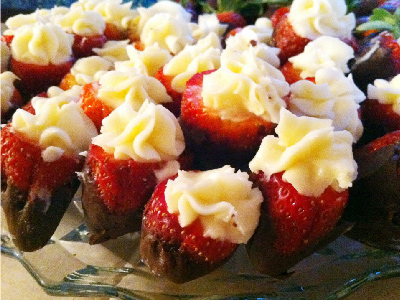 A dozen finished chocolate covered strawberries on a glass plate.